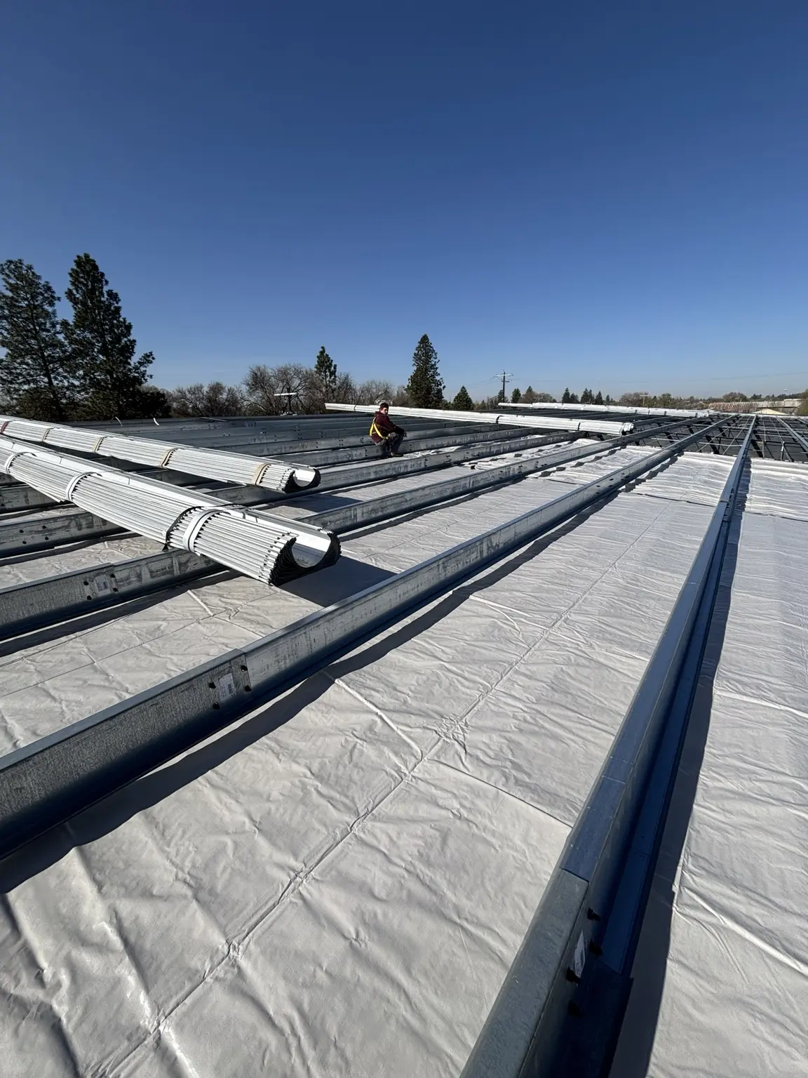 Metal building roof system and liner installation in progress