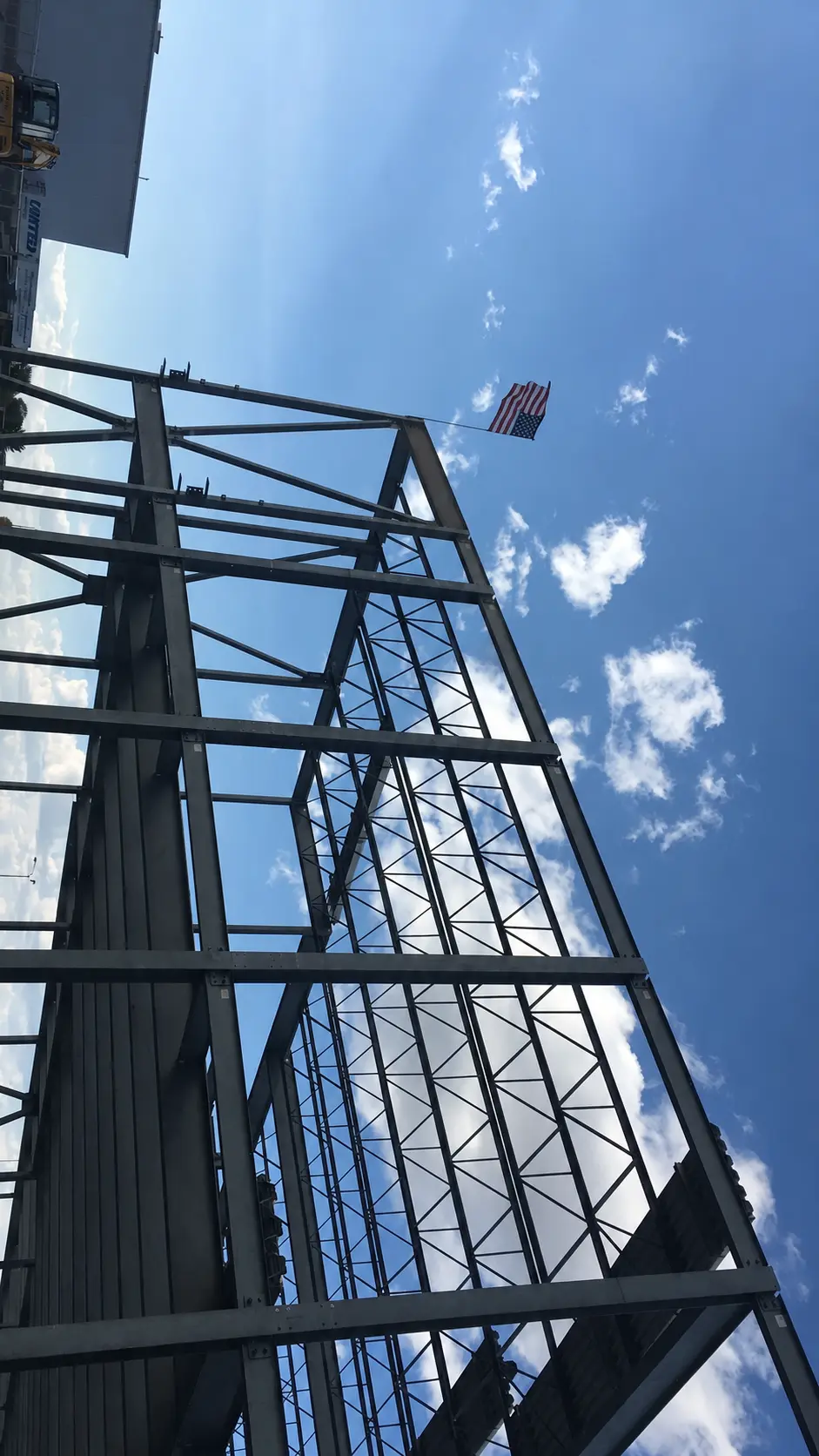 Steel building frame with an American flag during erection